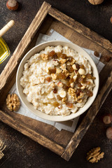 Oatmeal with nuts (hazelnuts, walnuts) and honey, porridge for Breakfast. Tasty, healthy food