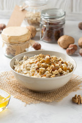 Oatmeal with nuts (hazelnuts, walnuts) and honey, porridge for Breakfast. Tasty, healthy food