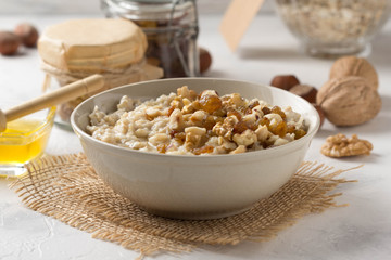 Oatmeal with nuts (hazelnuts, walnuts) and honey, porridge for Breakfast. Tasty, healthy food