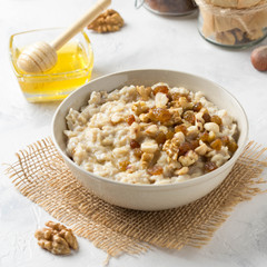 Oatmeal with nuts (hazelnuts, walnuts) and honey, porridge for Breakfast. Tasty, healthy food
