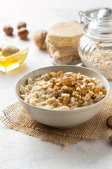 Oatmeal with nuts (hazelnuts, walnuts) and honey, porridge for Breakfast. Tasty, healthy food