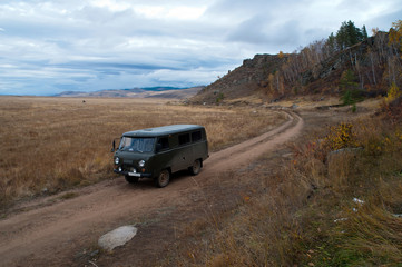 Obraz na płótnie Canvas Barguzin Valley Russia, Russian off-road van on remote valley road
