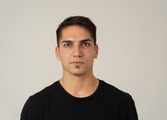 Natural portrait of young attractive man in his 20s looking and posing with neutral face expression - obrazy, fototapety, plakaty