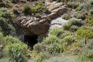 Lost places, Rusty grid barrier in front of a cave in Argientiera