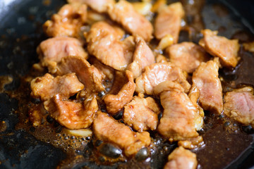 Stir fried pork with soy sauce in a hot pan, Asian food cooking