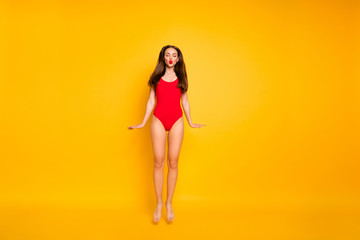 Fototapeta na wymiar Full length photo of stunning lady nice lifeguard jumping high sending air kiss visitors wear red swim suit isolated yellow background