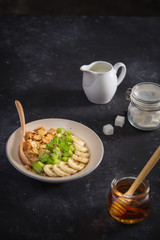 Ingredients tasty healthy breakfast for cooking with milk and oat flakes, banana, kiwi on pink background