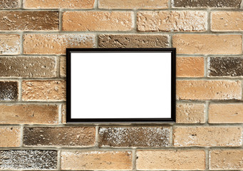 Fototapeta na wymiar A photo frame with white empty space for text hangs on an old brick wall. Grunge brick wall with a photoframe