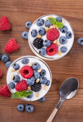 Two glasses of natural Greek yogurt and wild berries