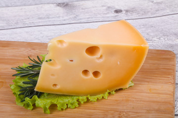 Maasdam cheese  in the board served salad leaves