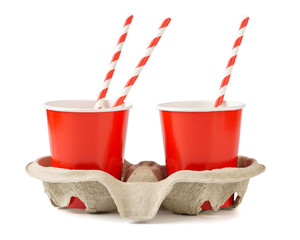 Red disposable paper cups with a cup carrier and straws.