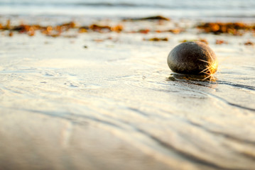 Stone on the beach, with Sun shining. 