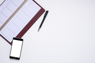 business arrangement. smartphone and notebook with pen on white background with copy space