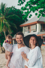 family holiday by the sea: man, woman and child on the beach. concept of travel