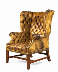 antique yellow leather wing chair isolated
