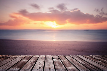 Fototapeta na wymiar Colorful beautiful cloudy sunset over ocean with wooden path