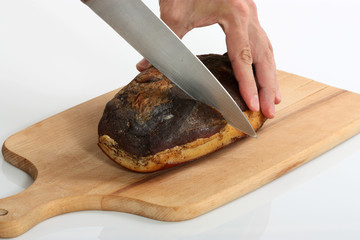 hands cutting homemade smoked meat