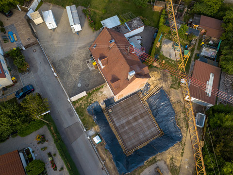 Aerial view of a construction site within a village in Germany. Looking straight down with a satellite image style, the houses look like a miniature village