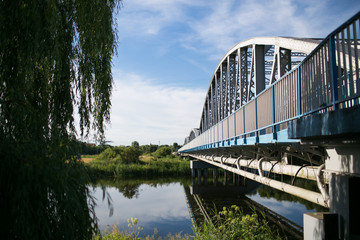 Metal bridge over the river water summer landscape.