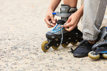 Woman putting on roller skates outdoor.