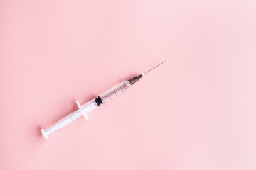 Medical syringe on pink background, health and vaccination concept. Flat lay, mockup, overhead, top...