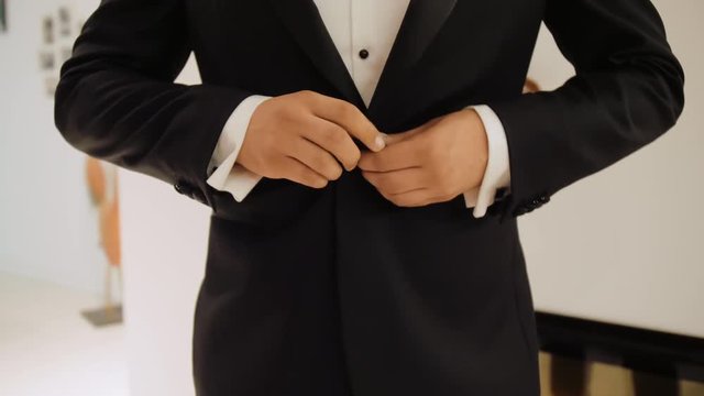 Groom Man in Festive White Shirt Fastens his Elegant Black Jacket. Close Up Static 4K Stock Video