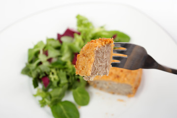 Cutlet on fork with salad