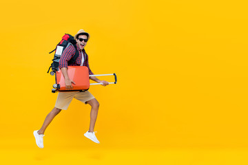 Handsome Indian tourist man with backpack holding baggage and jumping