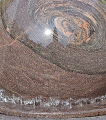 Reflection of a building in the ornamental street fountain.