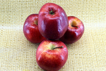 Four red ripe apples on a light background