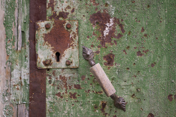 a close look at the rusty iron door with lock and handle