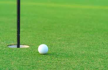 Golf ball on lip of cup at golf court