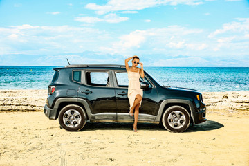 Summer background with a girl and black car in a beautiful sunny sandy beach and blue ocean view.