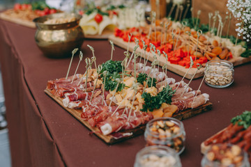 Decorated catering banquet table with different food snacks, sausage,salami,pepperoni sliced