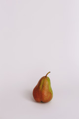 Sweet ripe fresh green pear with water drops, green leaves, spotted on white wood table.