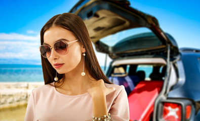 Summer background with a girl and black car in a beautiful sunny sandy beach and blue ocean view.