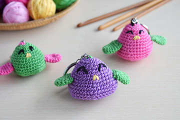 Making colored crochet bird. Toy for babies or trinket.  On the table threads, needles, hook,...