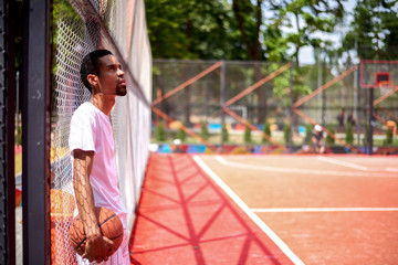 Black basketball player posing in the field outdoors