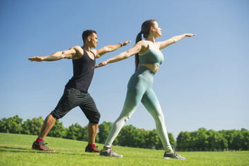 Fototapeta na wymiar Man and woman practicing yoga outdoor