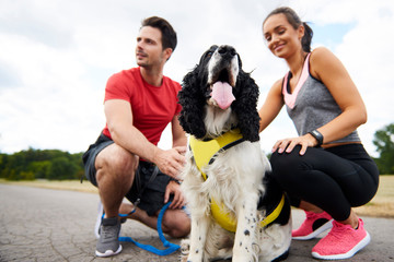 Young  couple and dog after workout on the fresh air