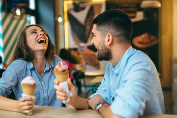 friends eating ice cream in cones in candy shop