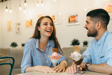 couple having fun eating ice cream in cafe