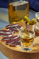 whiskey in two glasses and sliced jerky with spices on the oak surface. Close up.