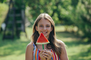 teenage girl holding watermelon outdoor