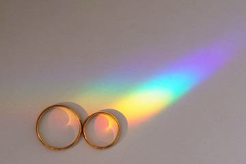 Background with two wedding rings with rainbow.