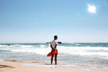 A lifeguard boy on the beach in a summer sunny day