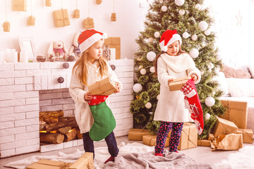 Kids little sisters hold gifts boxes interior background. What a great surprise. Small cute girls received holiday gifts. Best toys and christmas gifts. Children friends excited unpacking their gifts.