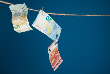 Dinero en billetes de euro, unido a un cordel por clips y billetes unidos entre ellos por clips.