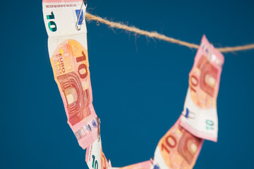 Dinero en billetes de euro, unido a un cordel por clips y billetes unidos entre ellos por clips.