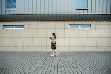 A woman with a paperbag near the supermarket. The concept of shopping, lifestyle.